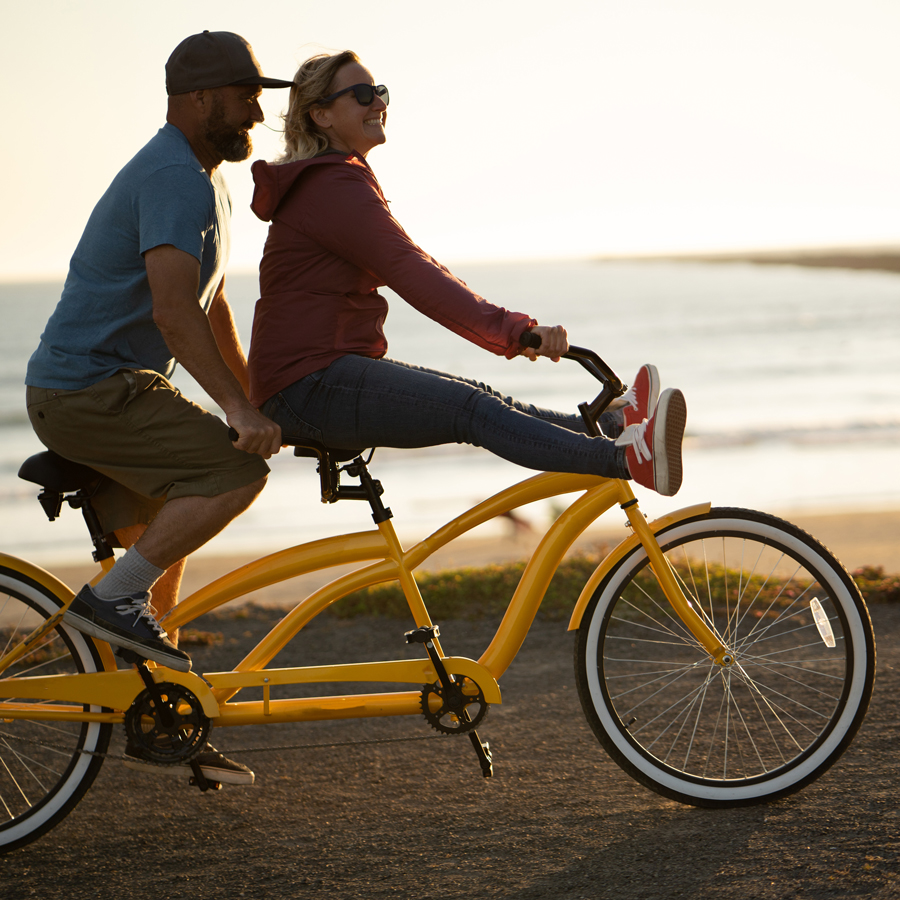 Couple on a tandem bike at sunset