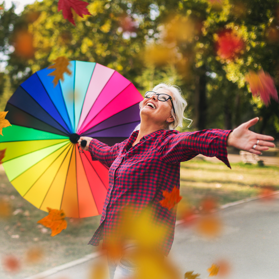 Woman holding a colorful umbrella in a park