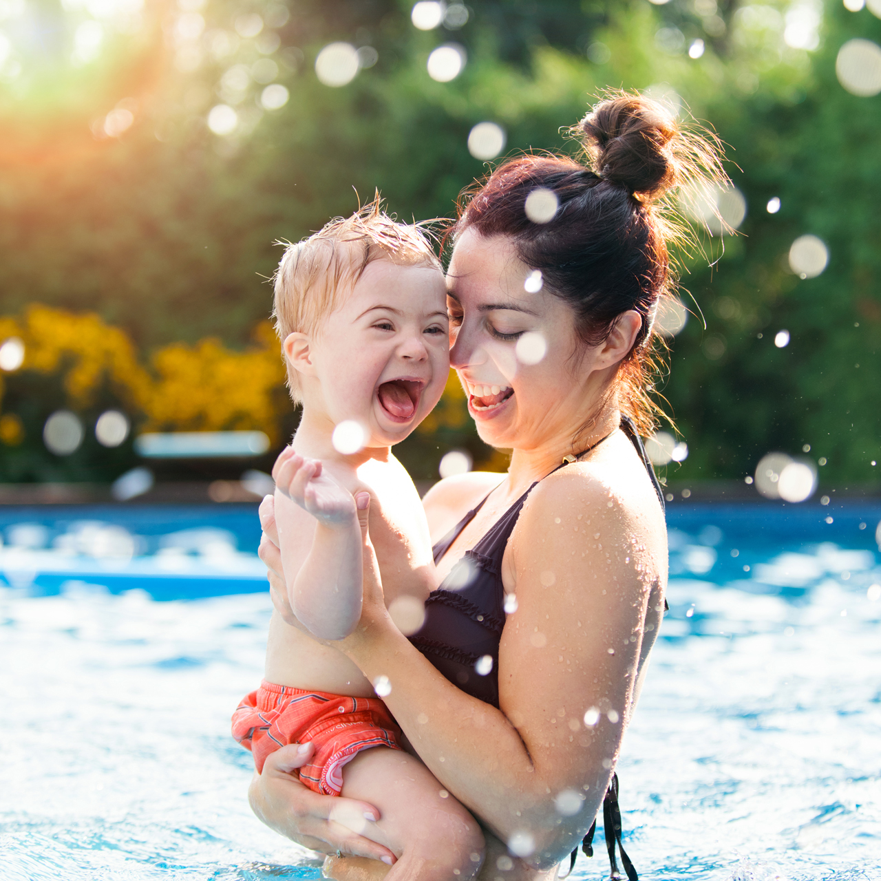 Woman holding son in pool