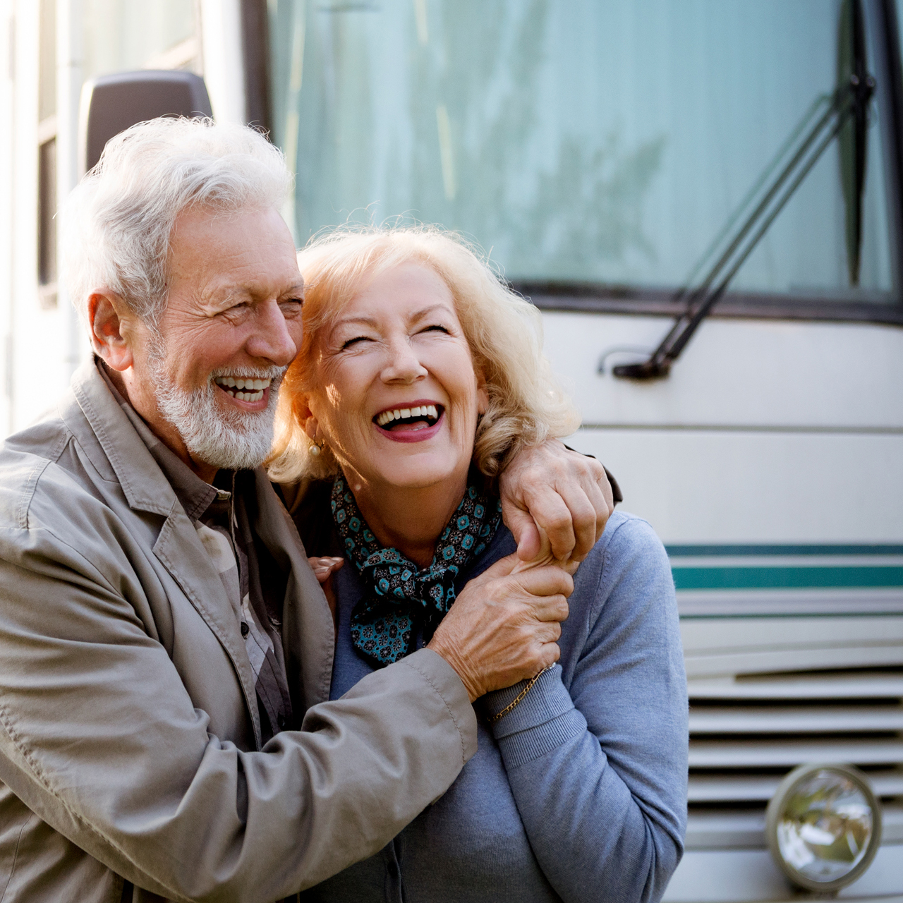 Older couple laughing near an RV
