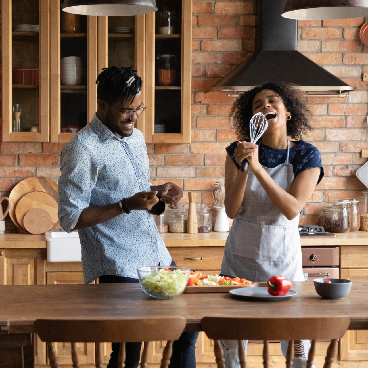 Couple singing and having fun in kitchen