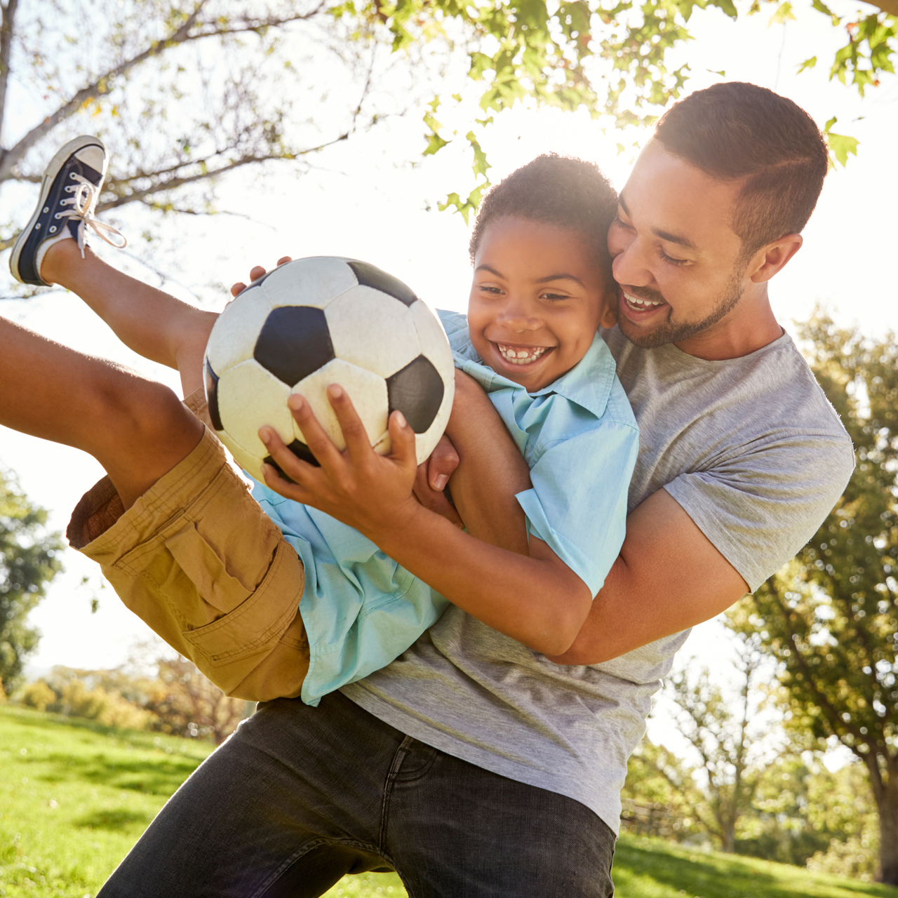 Father and son playing with a soccer ball