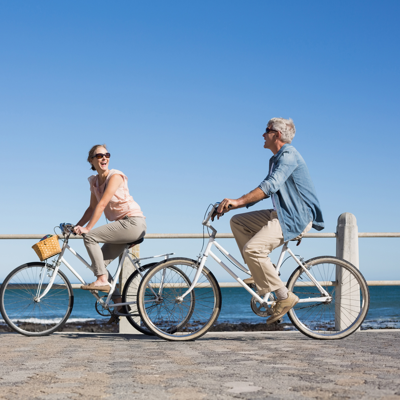 Couple riding bikes on a boardwalk